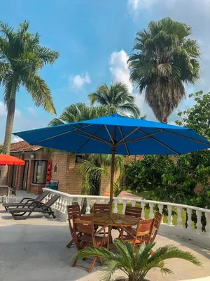 a table and chairs with a blue umbrella at La Manola Finca Hotel in Doradal