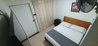 a small bedroom with a bed and a mirror at Hotel Gran Imperio in Medellín