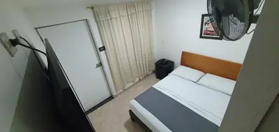 a small bedroom with a bed and a mirror at Hotel Gran Imperio in Medellín
