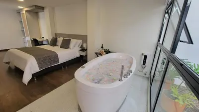 a bedroom with a tub with a bed and a bed at Hotel Piedras De Maní in Manizales