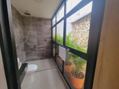 a bathroom with a toilet and a window with plants at Hotel Piedras De Maní in Manizales