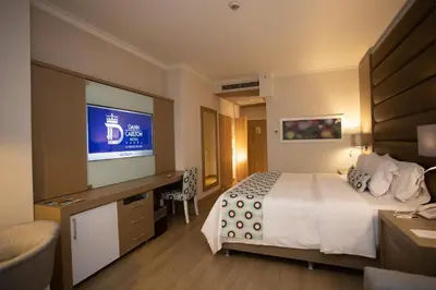 a hotel room with a bed and a flat screen tv at Hotel Dann Carlton Medellín in Medellín