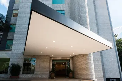 a large building with a large white shade on it at Hotel Poblado Alejandria in Medellín