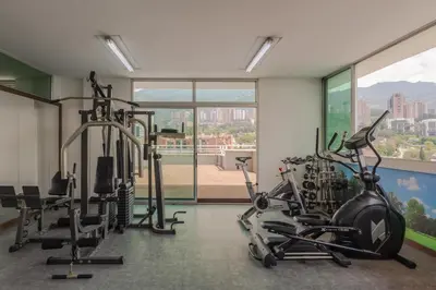 a gym with treadmills and cardio machines in a room at Hotel Poblado Alejandria in Medellín