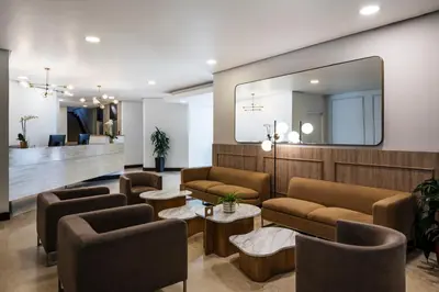 a waiting room with couches and a mirror at Hotel Poblado Alejandria in Medellín