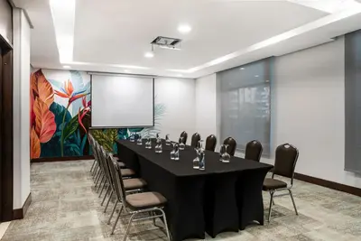 a conference room with a black table and chairs at Hotel Poblado Alejandria in Medellín
