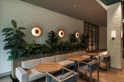 a restaurant with tables and couches and plants on the wall at Hotel Poblado Plaza in Medellín