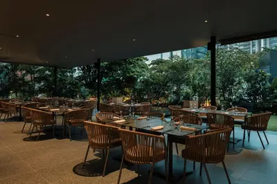 a restaurant with wooden tables and chairs on a patio at Hotel Poblado Plaza in Medellín