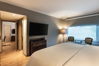 a bedroom with a large bed and a flat screen tv at Hotel Poblado Plaza in Medellín