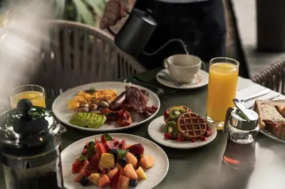 a table topped with plates of food and drinks at Hotel Poblado Plaza in Medellín