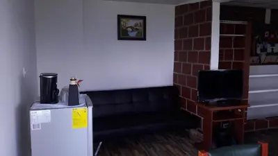 a room with a refrigerator and a tv at Palestina Ecohotel in Chinchiná