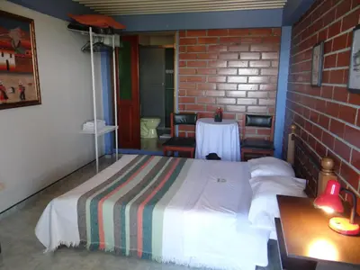 a bedroom with a bed and a table in it at Palestina Ecohotel in Chinchiná