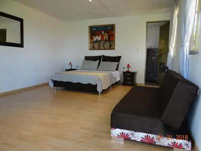 a bedroom with a bed and a couch at Palestina Ecohotel in Chinchiná
