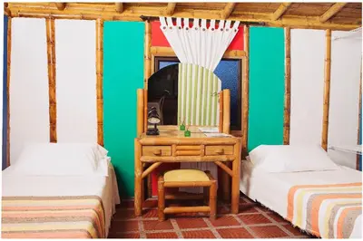 a room with two beds and a desk and a mirror at Palestina Ecohotel in Chinchiná