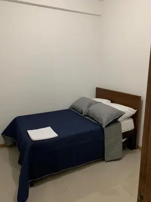 a bedroom with a bed with a blue comforter at Apartasol in Santa Fe de Antioquia