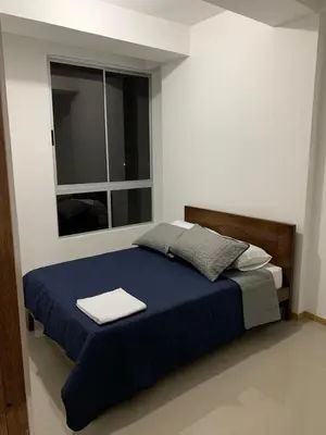 a bedroom with a blue bed with a window at Apartasol in Santa Fe de Antioquia