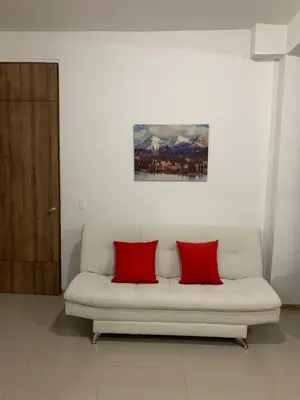 a white couch with two red pillows in a room at Apartasol in Santa Fe de Antioquia