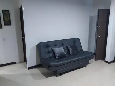 a blue couch with two pillows in a room at Apartasol in Santa Fe de Antioquia