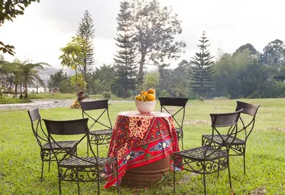 a table with chairs and a bowl of fruit on it at La Casa de Piedra in Guatapé
