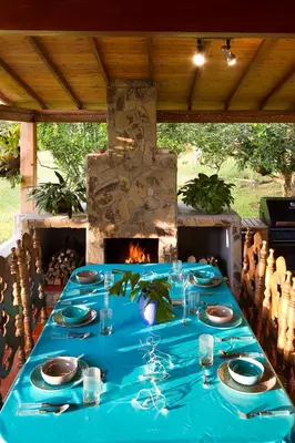 a table with a blue table cloth and a fireplace at La Casa de Piedra in Guatapé
