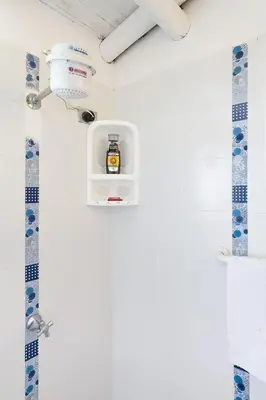 a bathroom with a shower with a soap dispenser at La Casa de Piedra in Guatapé