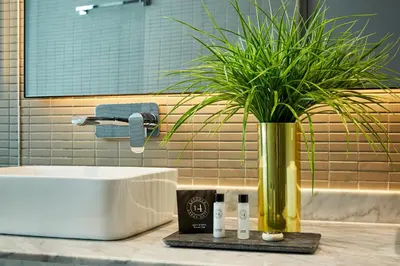a bathroom with a sink and a potted plant on a counter at 14 Urban Hotel in Medellín