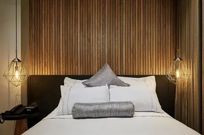 a bedroom with a bed with white sheets and pillows at 14 Urban Hotel in Medellín