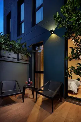 a room with two chairs and a bed in a building at 14 Urban Hotel in Medellín