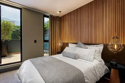 a bedroom with a large bed and a large window at 14 Urban Hotel in Medellín