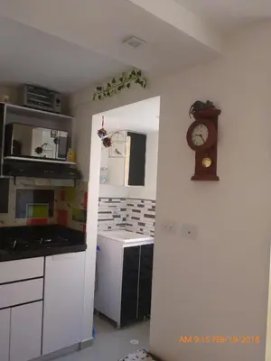 a kitchen with a clock on the wall and a counter at Cerca al estadio familiar parqueadero piscina in Medellín