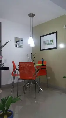 a dining room with a table and red chairs at Cerca al estadio familiar parqueadero piscina in Medellín