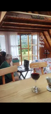 a man sitting at a table with a glass of wine at Cerca al estadio familiar parqueadero piscina in Medellín