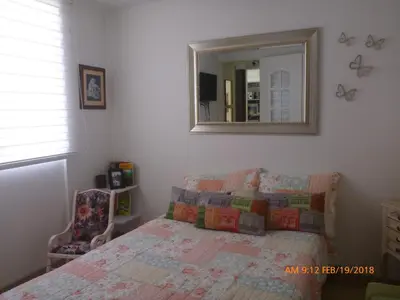 a bedroom with a bed and a mirror at Cerca al estadio familiar parqueadero piscina in Medellín