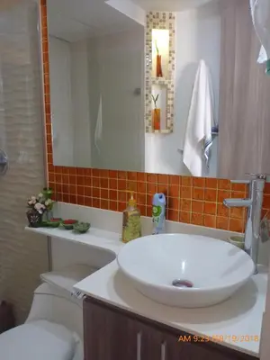 a bathroom with a sink and a toilet and a mirror at Cerca al estadio familiar parqueadero piscina in Medellín