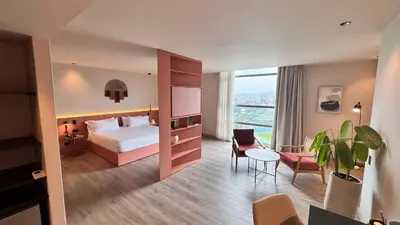 a hotel room with a bed and a table at Tequendama Hotel Medellín - Estadio in Medellín