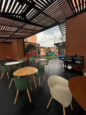 a restaurant with tables and chairs and a playground at Tequendama Hotel Medellín - Estadio in Medellín