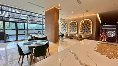 a restaurant with tables and chairs in a room at Tequendama Hotel Medellín - Estadio in Medellín
