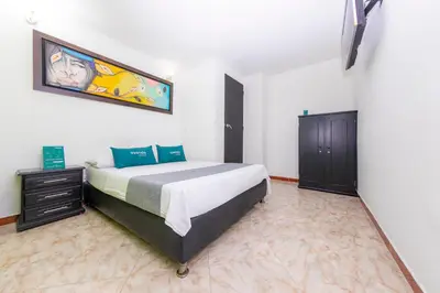 a bedroom with a bed and a painting on the wall at Ayenda Florida Nueva in Medellín