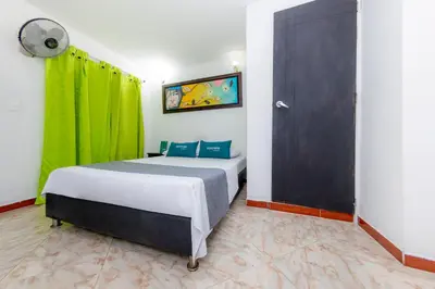 a bedroom with a bed and a green curtain at Ayenda Florida Nueva in Medellín