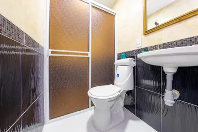 a bathroom with a toilet and a sink at Ayenda Florida Nueva in Medellín
