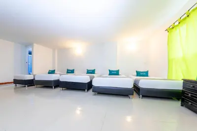 a room with four beds and a tv in it at Ayenda Florida Nueva in Medellín