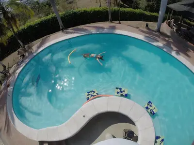 a person swimming in a swimming pool at Finca Galicia in Sopetran