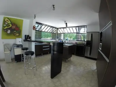 a kitchen with a counter and some chairs in it at Finca Galicia in Sopetran