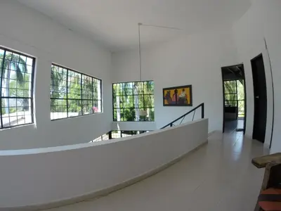 a room with white walls and windows and a staircase at Finca Galicia in Sopetran