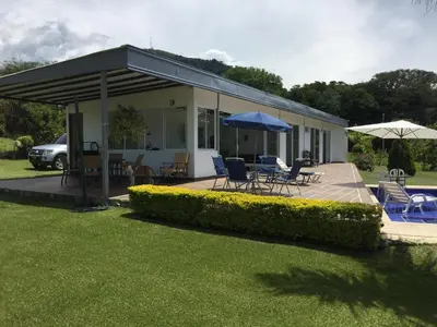 a house with a deck with chairs and umbrellas at Finca La Ranchera No. 2 in Tarso