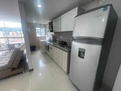 a white refrigerator in a kitchen with a couch at Apartamento relajante, amplio, moderno e iluminado, Sabaneta, Medellín , 3 alcobas in Sabaneta