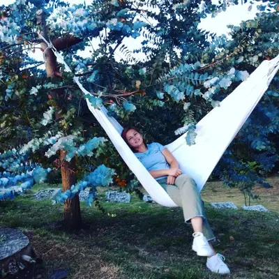 a woman laying in a hammock in a tree at Cabañas La Silleta in Santa Elena