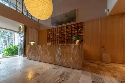 a lobby with a large stone counter in the middle of a room at The Charlee Hotel in Medellín