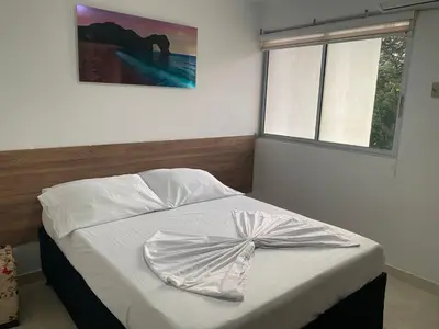 a bed with a dress on it in a bedroom at Apartamento en Condominio in San Jerónimo