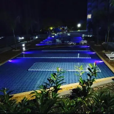 a large swimming pool with blue lights at night at Apartamento en Condominio in San Jerónimo